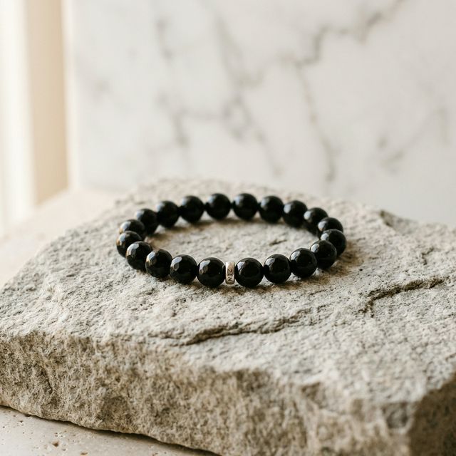 Black obsidian bracelet on a neutral stone surface